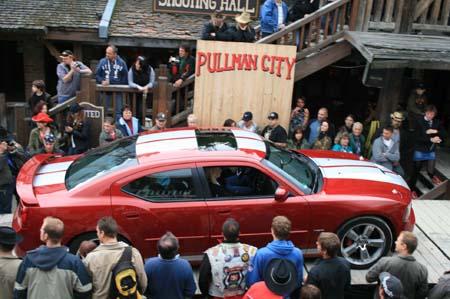 Roter Dodge Charger mit weissen GT-Streifen bei der fahrt auf die Bühne bem Giganten Treffen in Pullman City