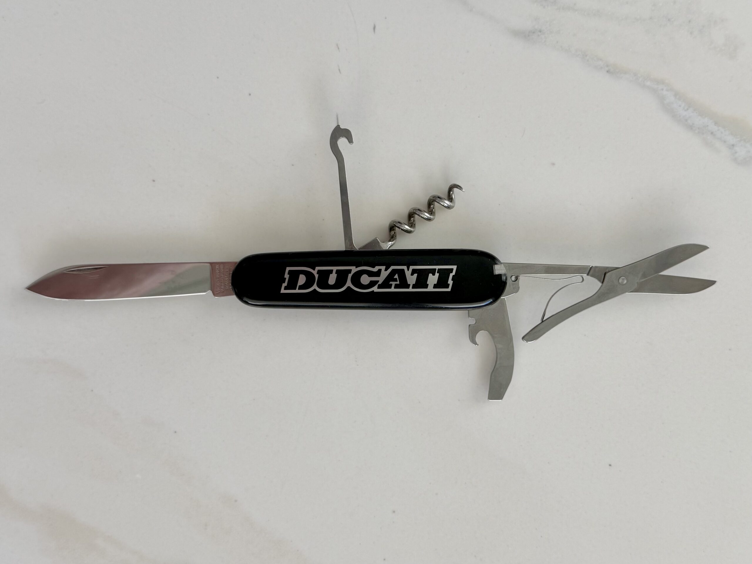 Geöffnetes Ducati Victorinox Compact 13405 Taschenmesser mit Klinge Schere Korkenzieher Mehrzweckhaken Offiziersmesser Schweiz Geöffnetes Ducati Victorinox Compact 13405 Taschenmesser mit Klinge Schere Korkenzieher Mehrzweckhaken Offiziersmesser Schweiz