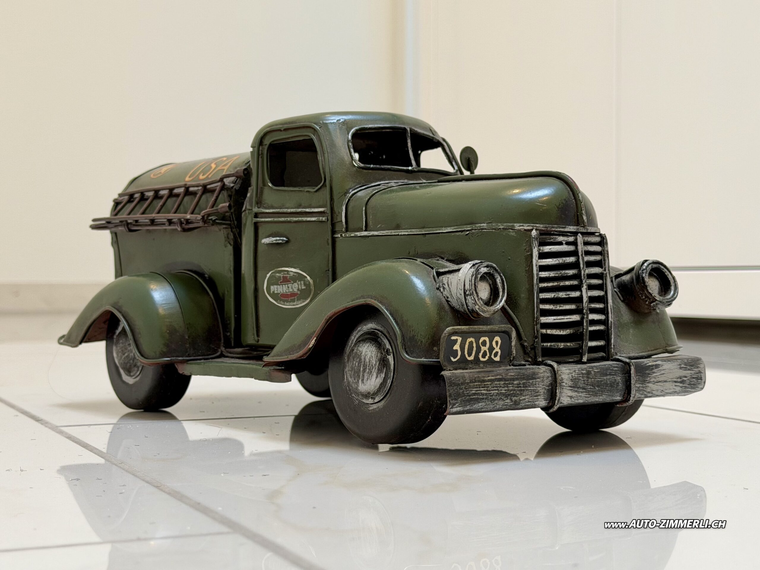 Federal Truck Tankwagen Pennzoil Metallmodell USA Vintage Blechmodell Oldtimer LKW Front Links Vintage Pennzoil Tankwagen Metallmodell im Stil eines Federal Truck von 1947. Dekorativer amerikanischer Oldtimer Tanklastwagen aus Metall mit Militärgrün Lackierung, Tankaufbau, authentischer Vintage Patina und zahlreichen liebevollen Details. Länge ca. 32 cm, Höhe ca. 15 cm.